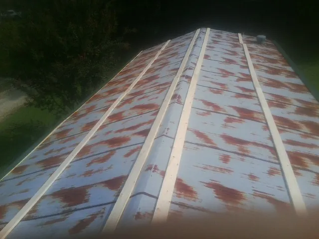 Rusted metal roof panels with new wood purlins before replacement — Storm Damage Roof Repair in Obion by Roofing Brothers
