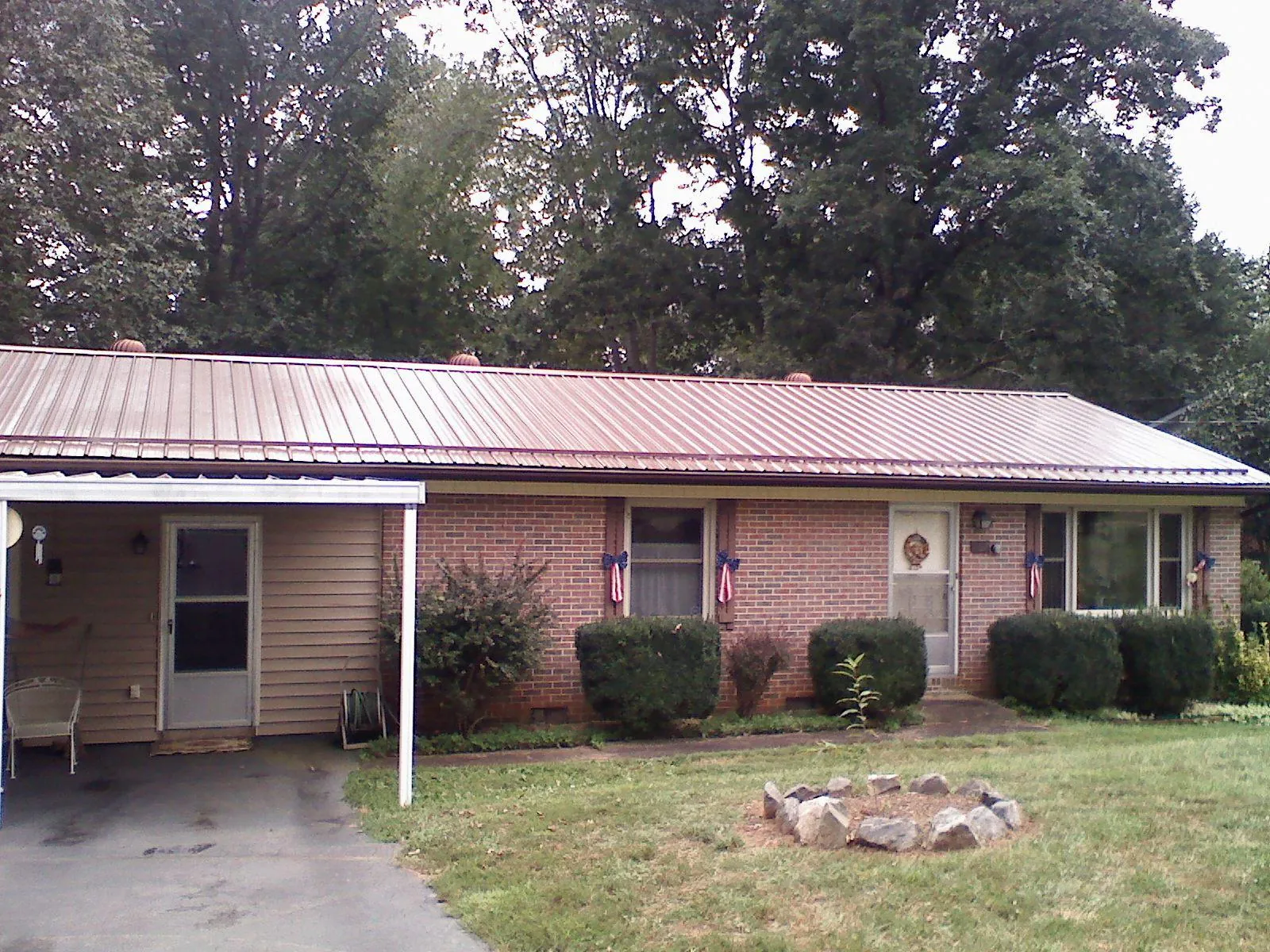 Bronze metal roof and carport on a brick ranch home — Roof Repair work by our crew in Obion