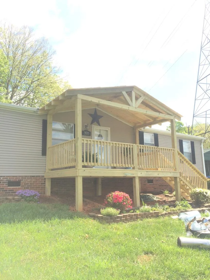 New gabled porch roof and deck railing added to a ranch home in Obion